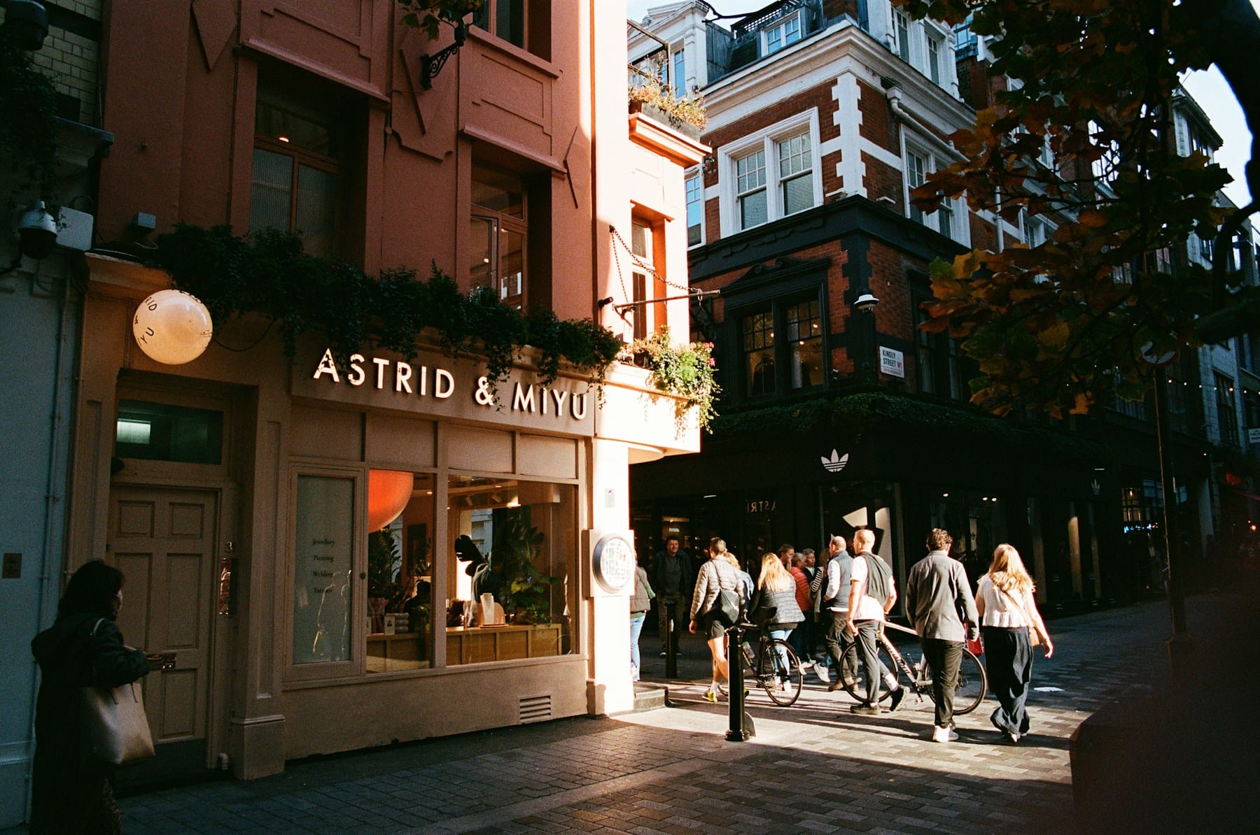 People shopping on a London street, with independent shopfronts and brick buildings